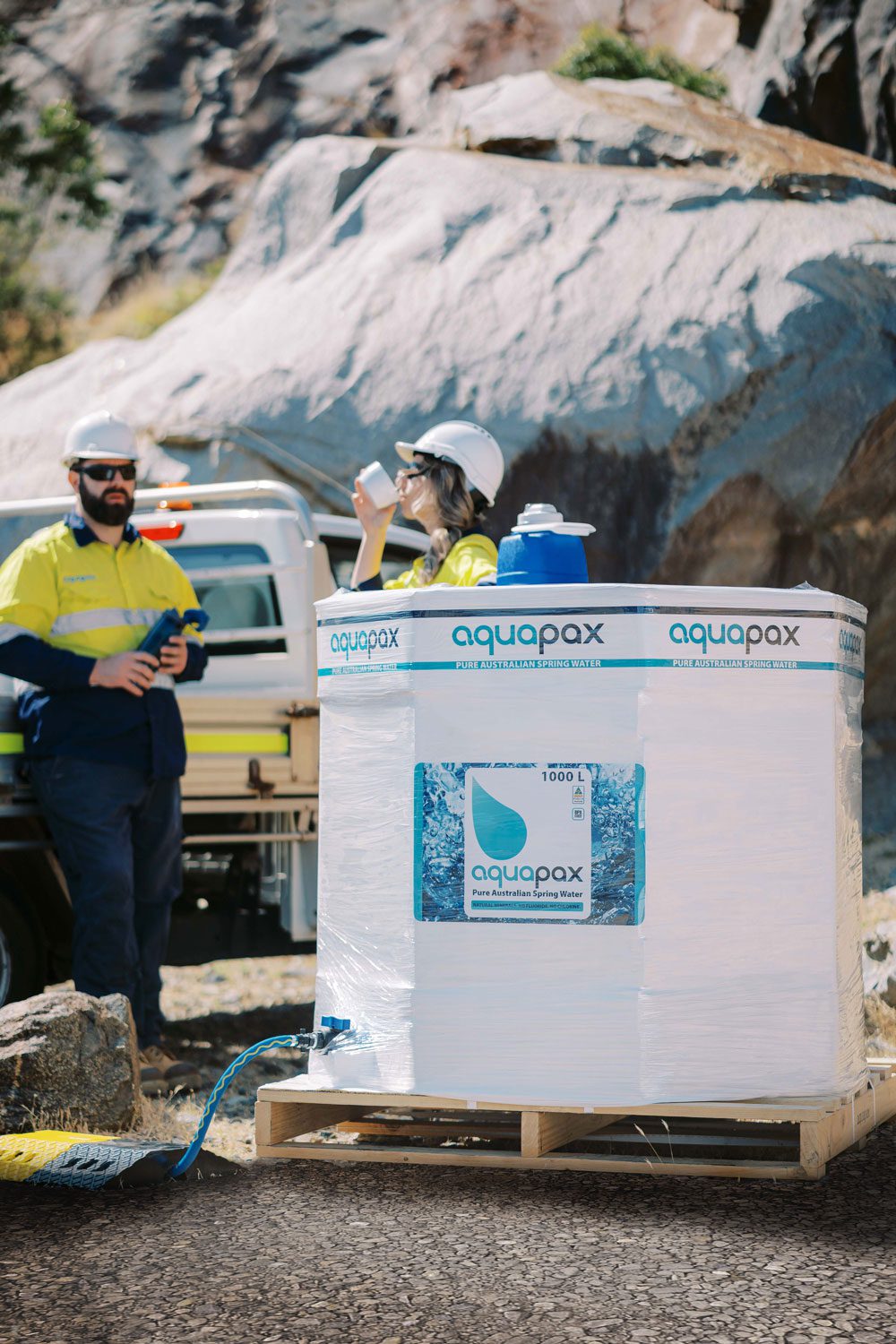 Two workers taking a break next to an Aquapax 1000L Water Pod