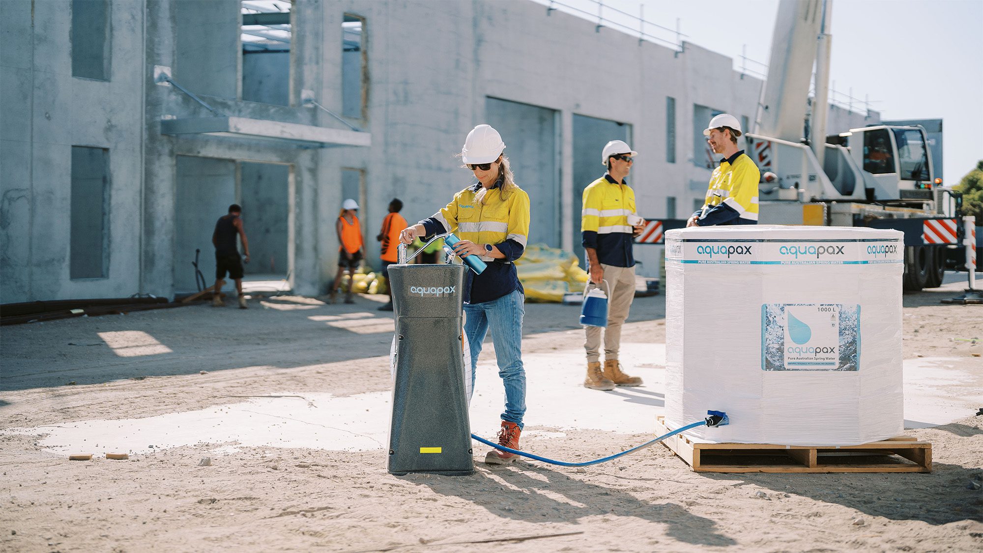 a woman filling her drink bottle up on a construction site from the Aquapax bubbler