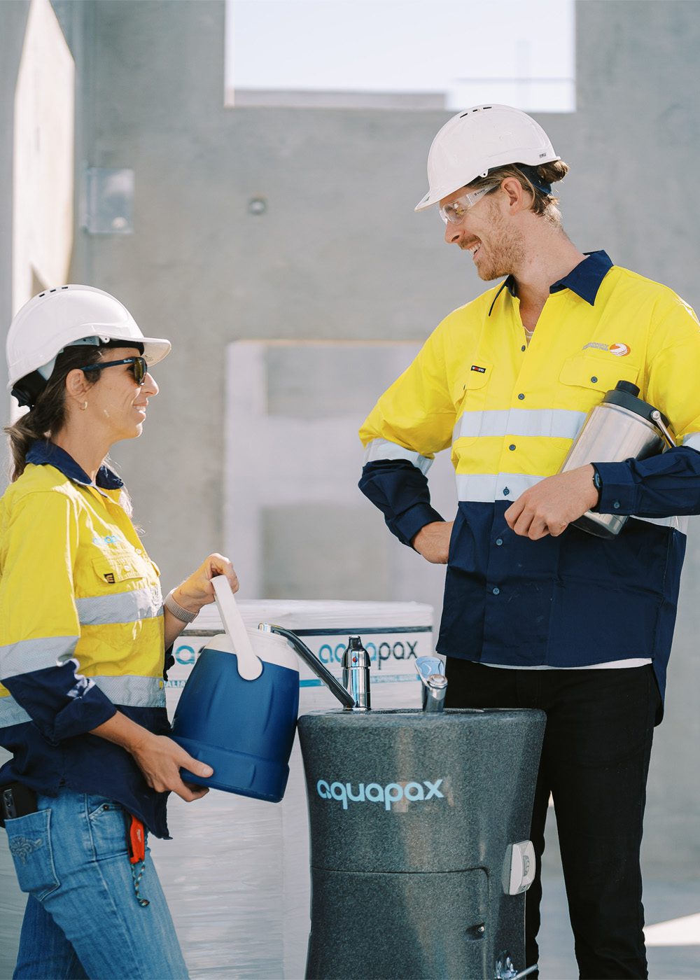 Two construction workers chatting around an Aquapax water dispenser