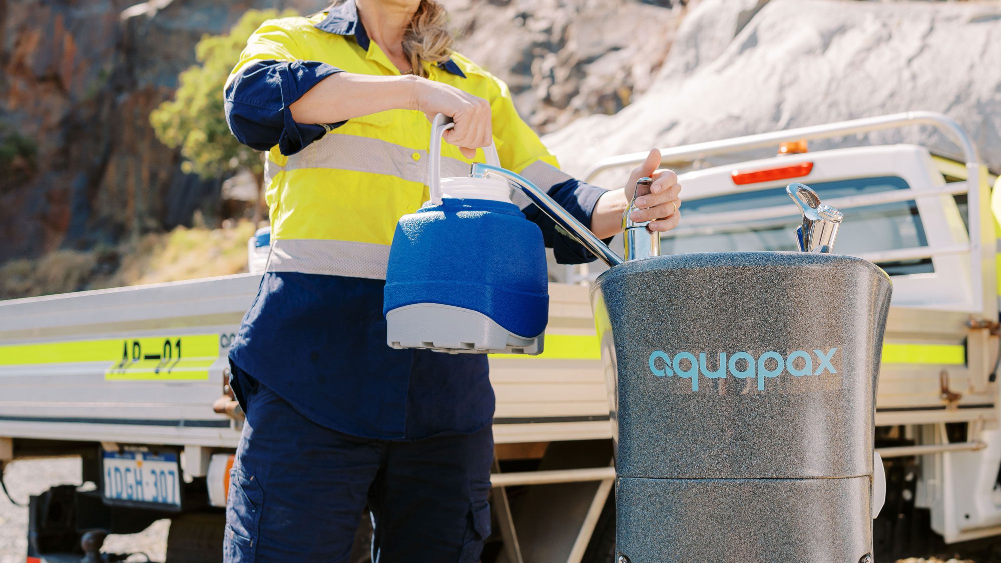 A construction worker filling up a water jug from an Aquapax water dispenser
